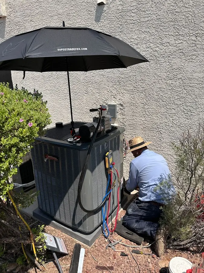 HVAC technician performing outdoor AC maintenance in Great Bend